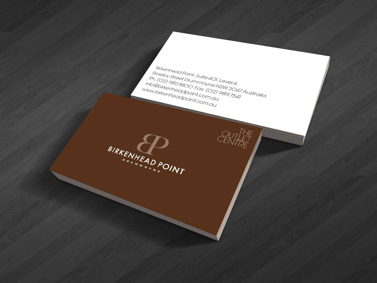 Brown and white Birkenhead Point business cards on a dark wooden surface