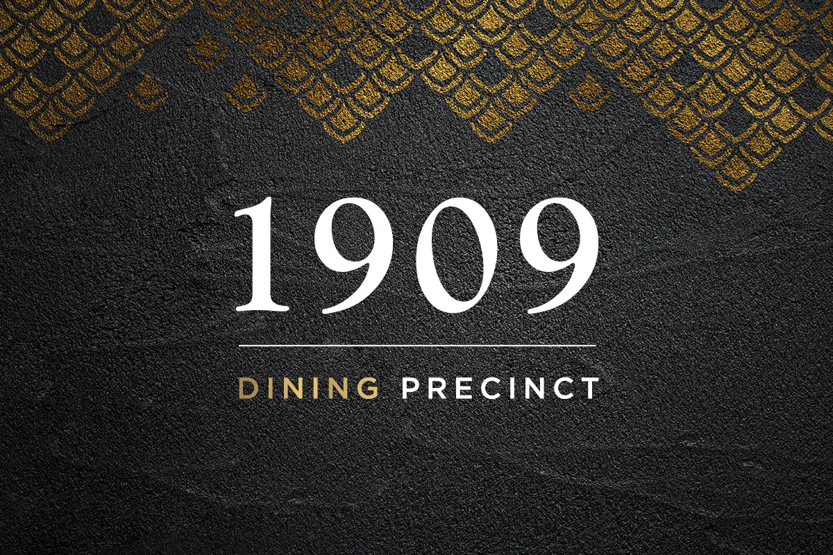 The 1909 Dining Precinct logo in white and gold on dark stone, with a gold scale pattern